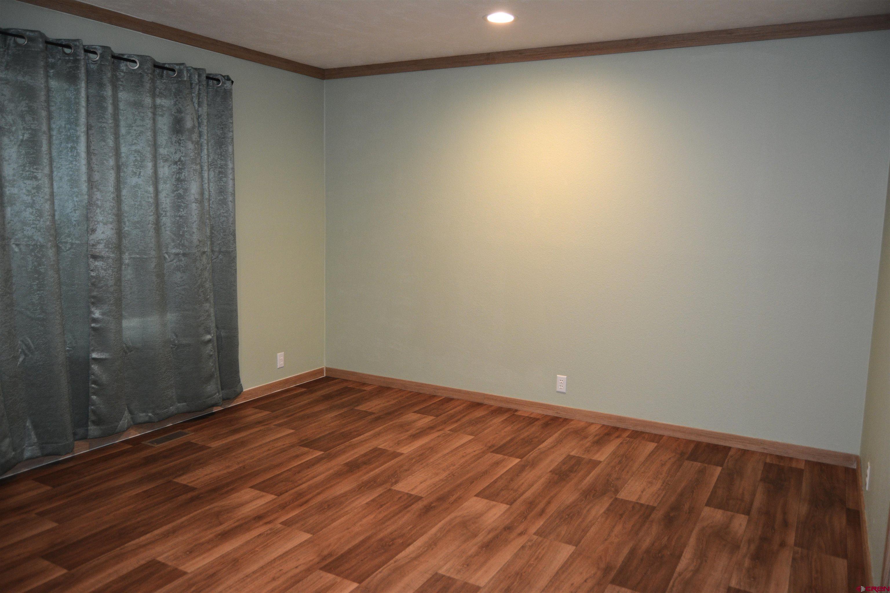 901 6530 Road, Unit 1030 Montrose, CO 81401 - Photo 19 of 22 a view of an empty room with wooden floor and a window