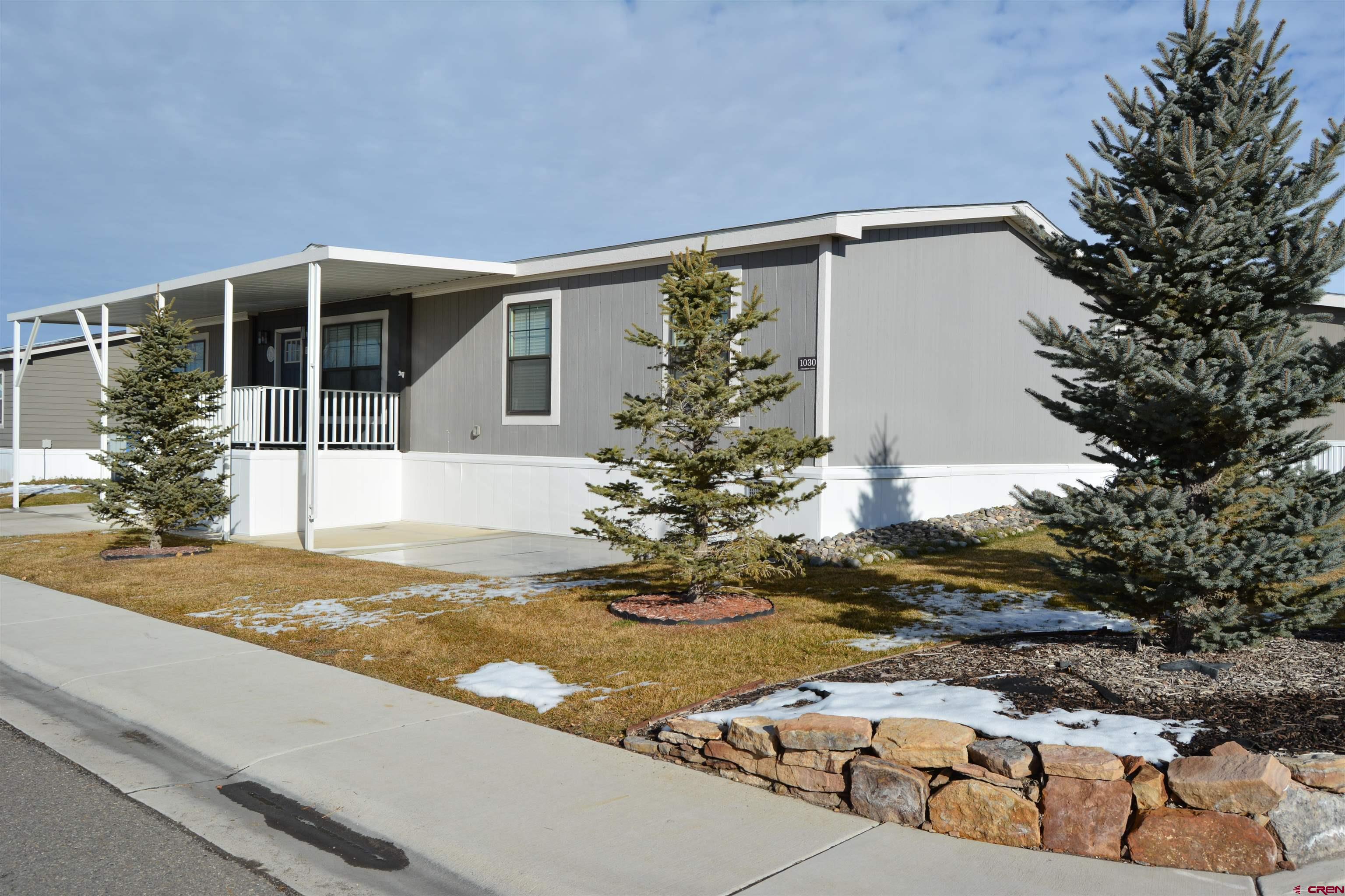 901 6530 Road, Unit 1030 Montrose, CO 81401 - Photo 2 of 22 a front view of a house with garden