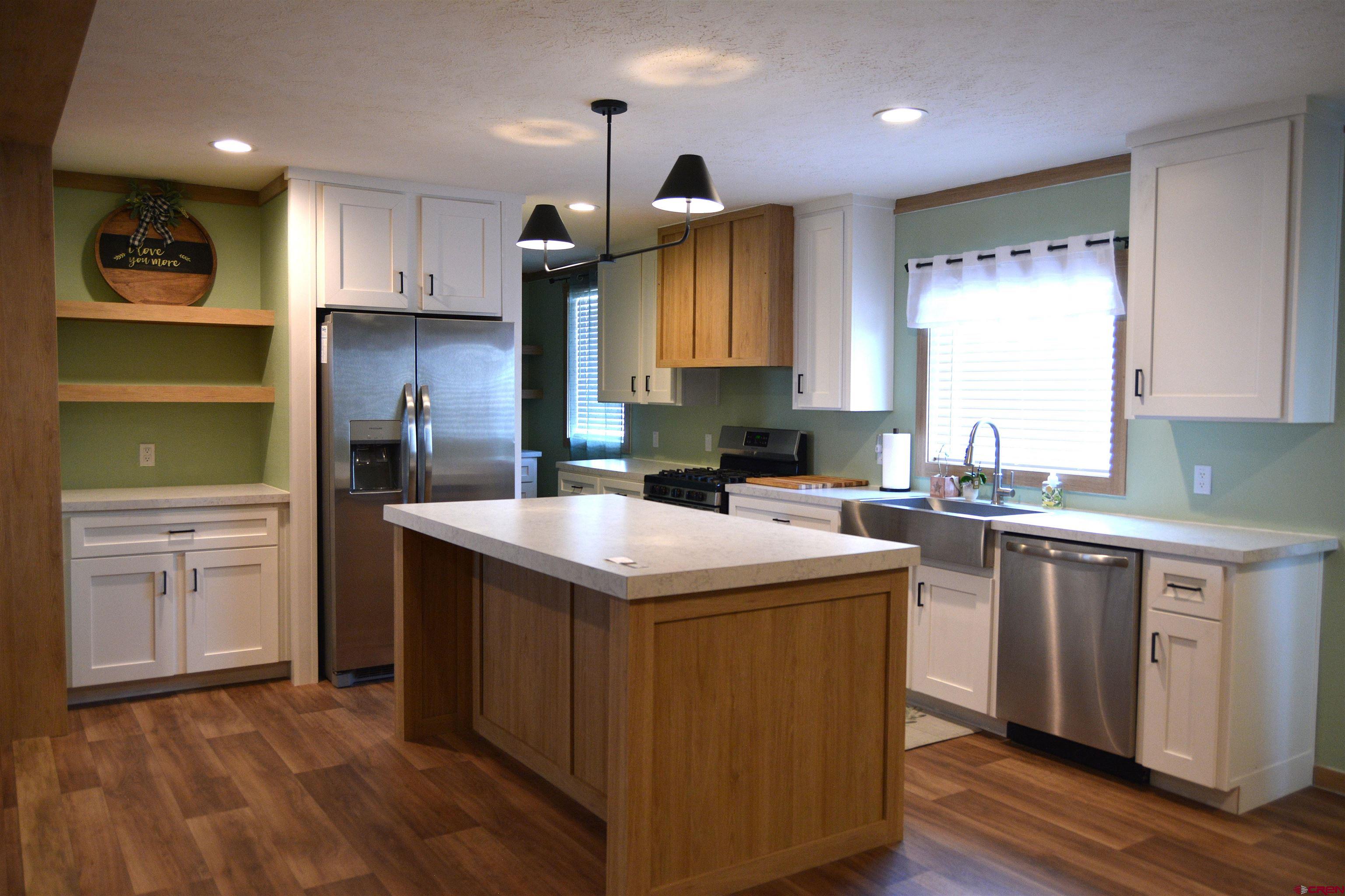 901 6530 Road, Unit 1030 Montrose, CO 81401 - Photo 3 of 22 a kitchen with kitchen island granite countertop a sink stove and refrigerator