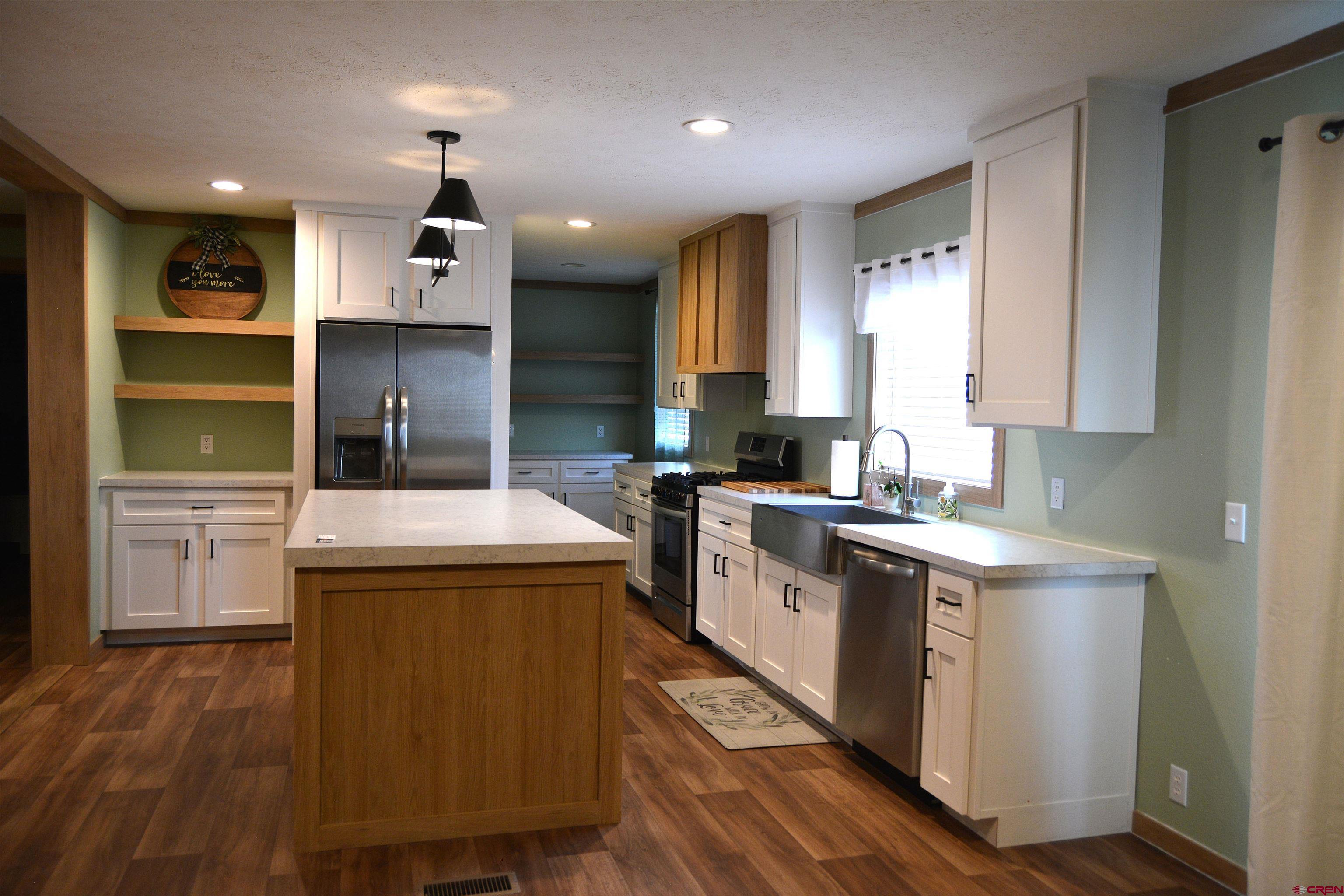 901 6530 Road, Unit 1030 Montrose, CO 81401 - Photo 5 of 22 a kitchen with a stove sink and a refrigerator