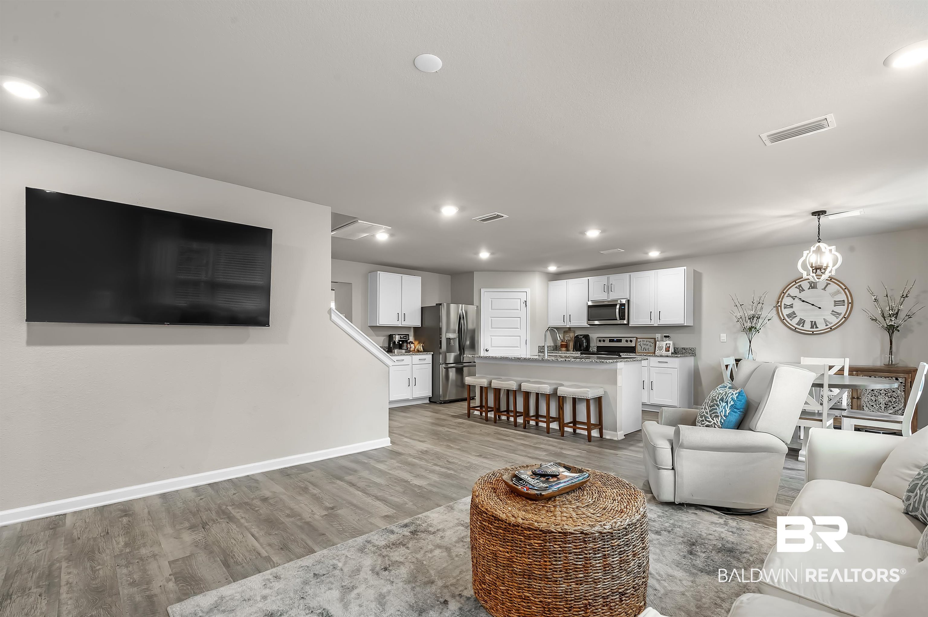 24549 Broken Sound Loop Orange Beach, AL 36561 - Photo 11 of 57 Living room with an inviting chandelier and light hardwood / wood-style flooring