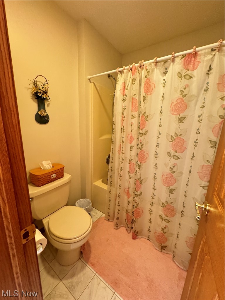 9615 Johnnycake Ridge Road Mentor, OH 44060 - Photo 30 of 35 Bathroom with shower / bathtub combination with curtain, toilet, and tile floors