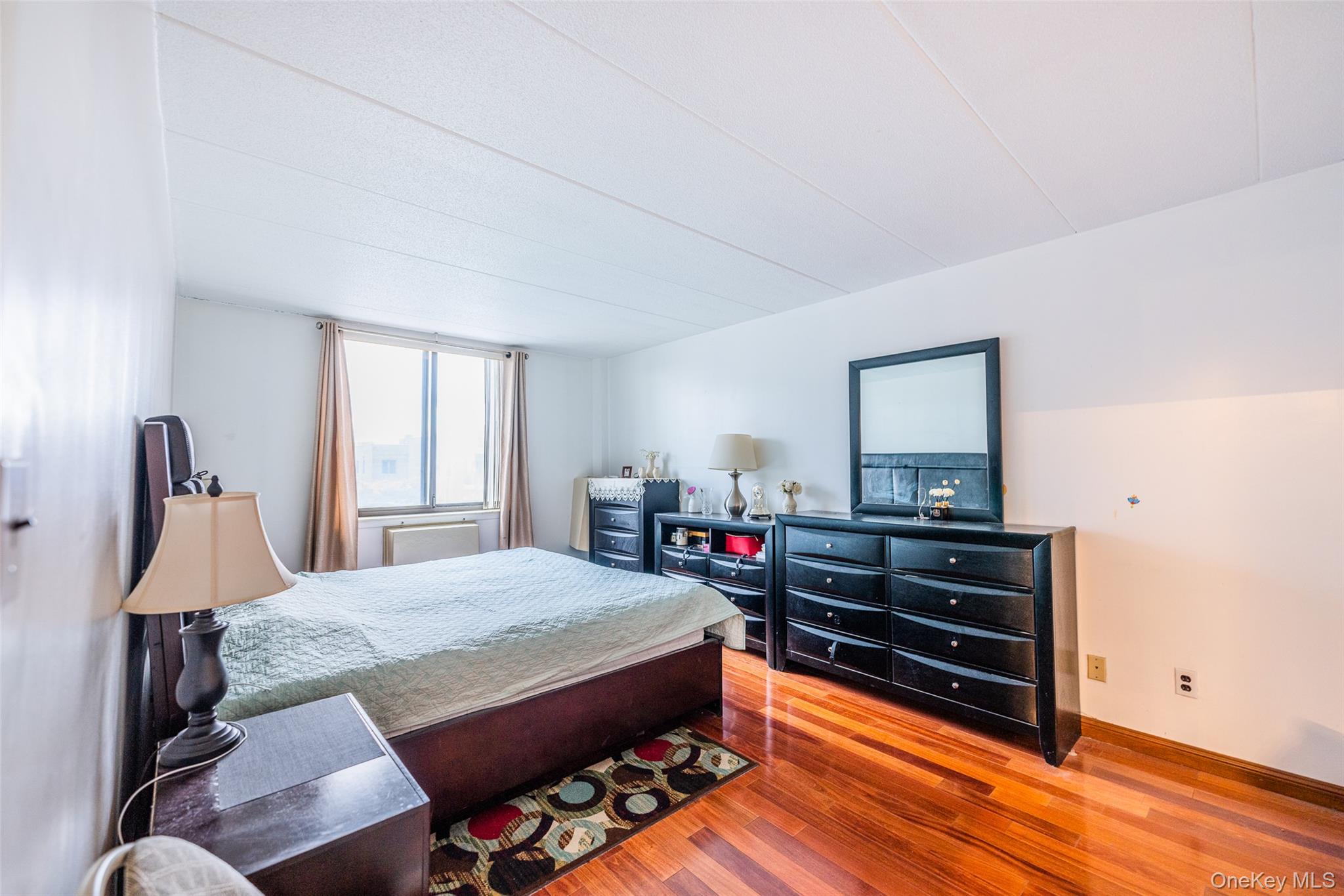 136-24 Maple Avenue, Unit 6F Queens, NY 11355 - Photo 11 of 29 a bedroom with a bed and wooden floor