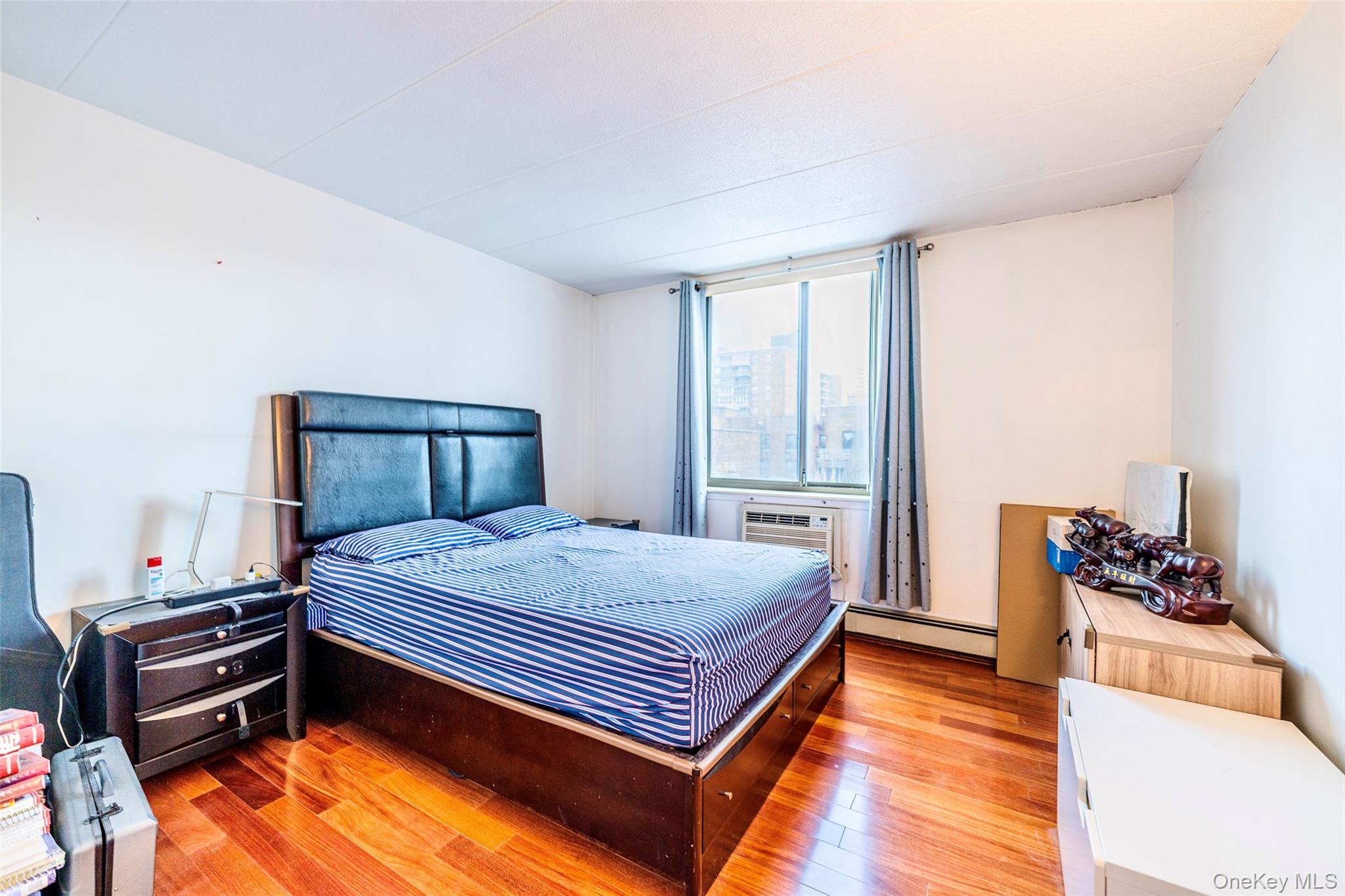 136-24 Maple Avenue, Unit 6F Queens, NY 11355 - Photo 12 of 29 a bedroom with a bed and a dresser in it