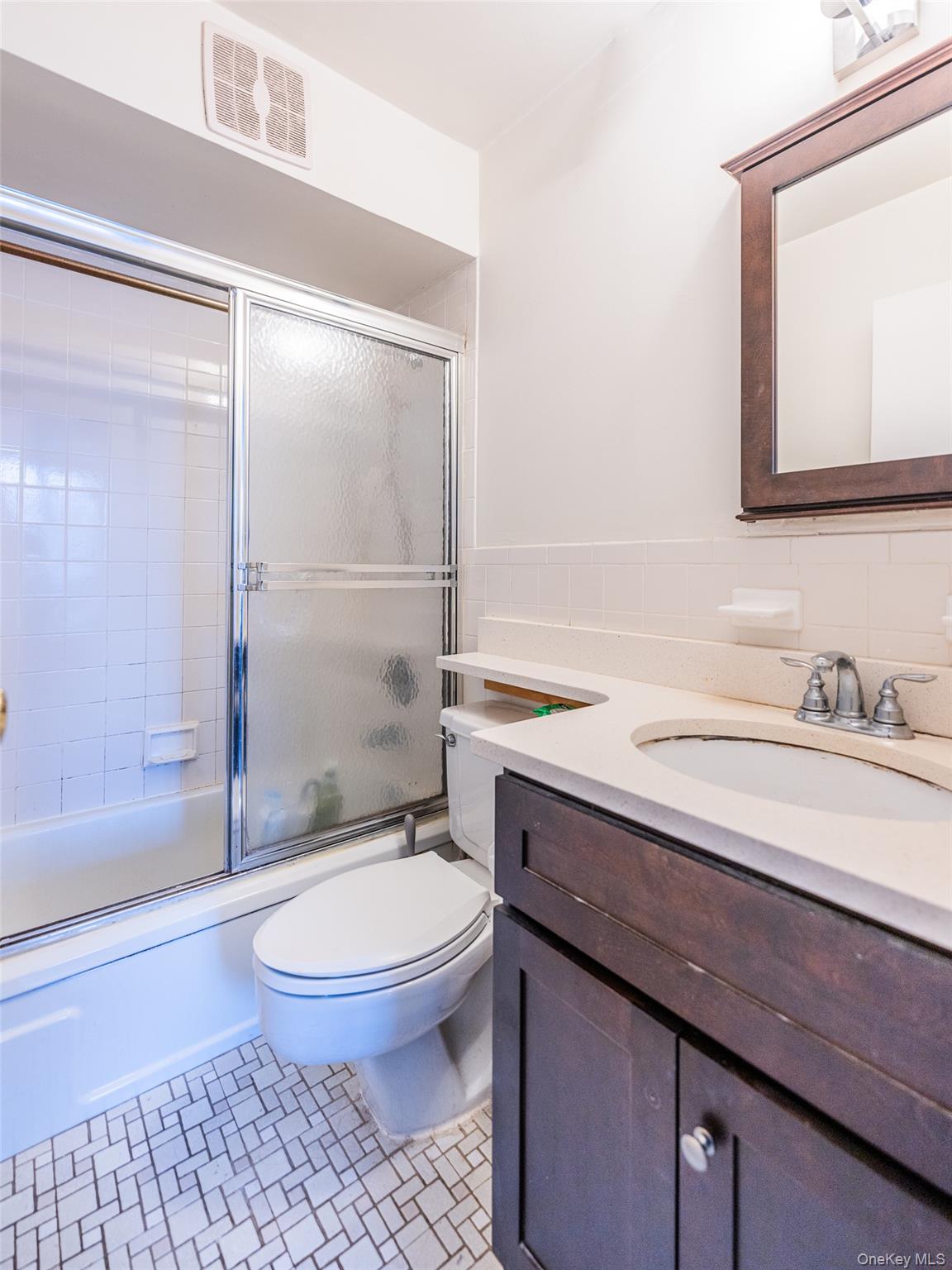 136-24 Maple Avenue, Unit 6F Queens, NY 11355 - Photo 13 of 29 a bathroom with a granite countertop sink toilet a mirror and shower