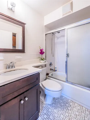 a bathroom with a granite countertop sink toilet a mirror and shower