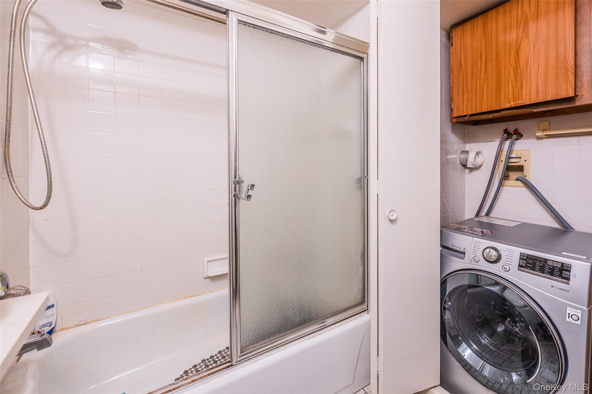 136-24 Maple Avenue, Unit 6F Queens, NY 11355 - Photo 15 of 29 a bathroom with a shower a washer and dryer