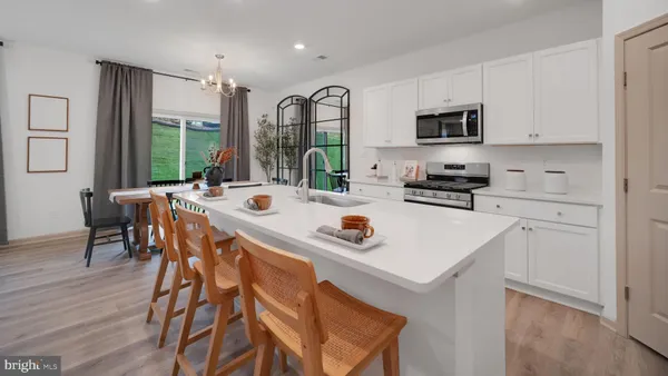 a kitchen with stainless steel appliances kitchen island granite countertop a sink a stove and cabinets