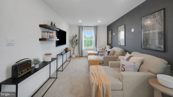 a living room with furniture a flat screen tv and a window