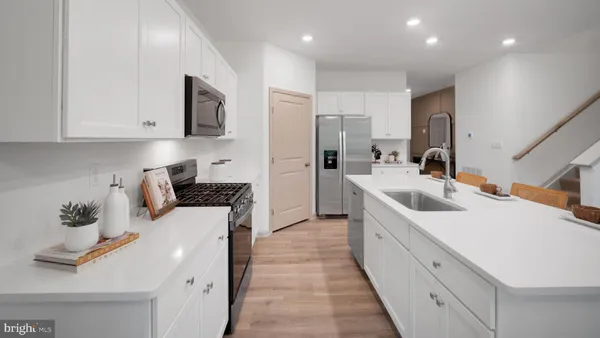 a kitchen with stainless steel appliances a sink stove and cabinets