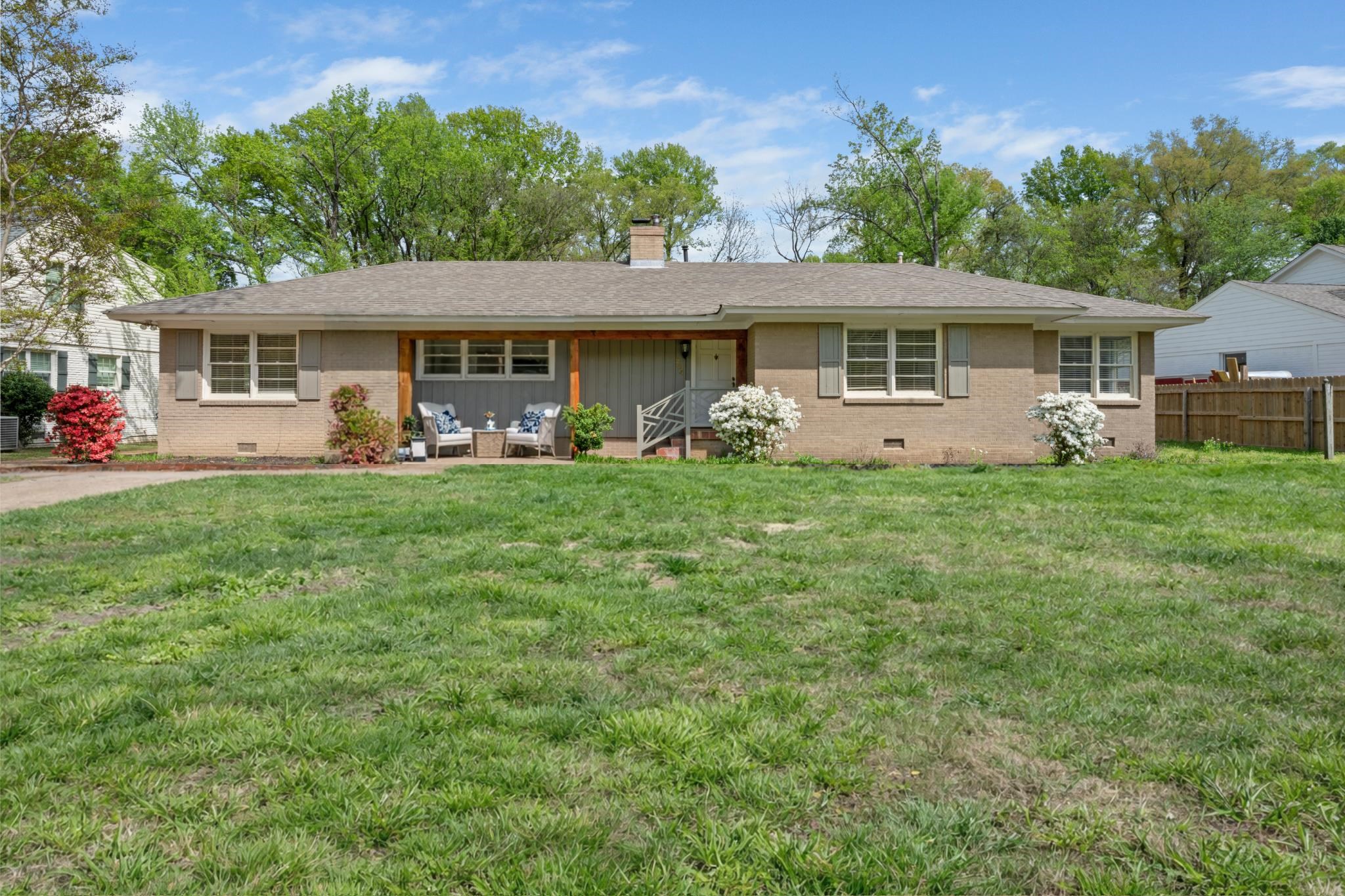 Painted brick exterior with timeless charm and welcoming front porch in a sought-after East Memphis location.