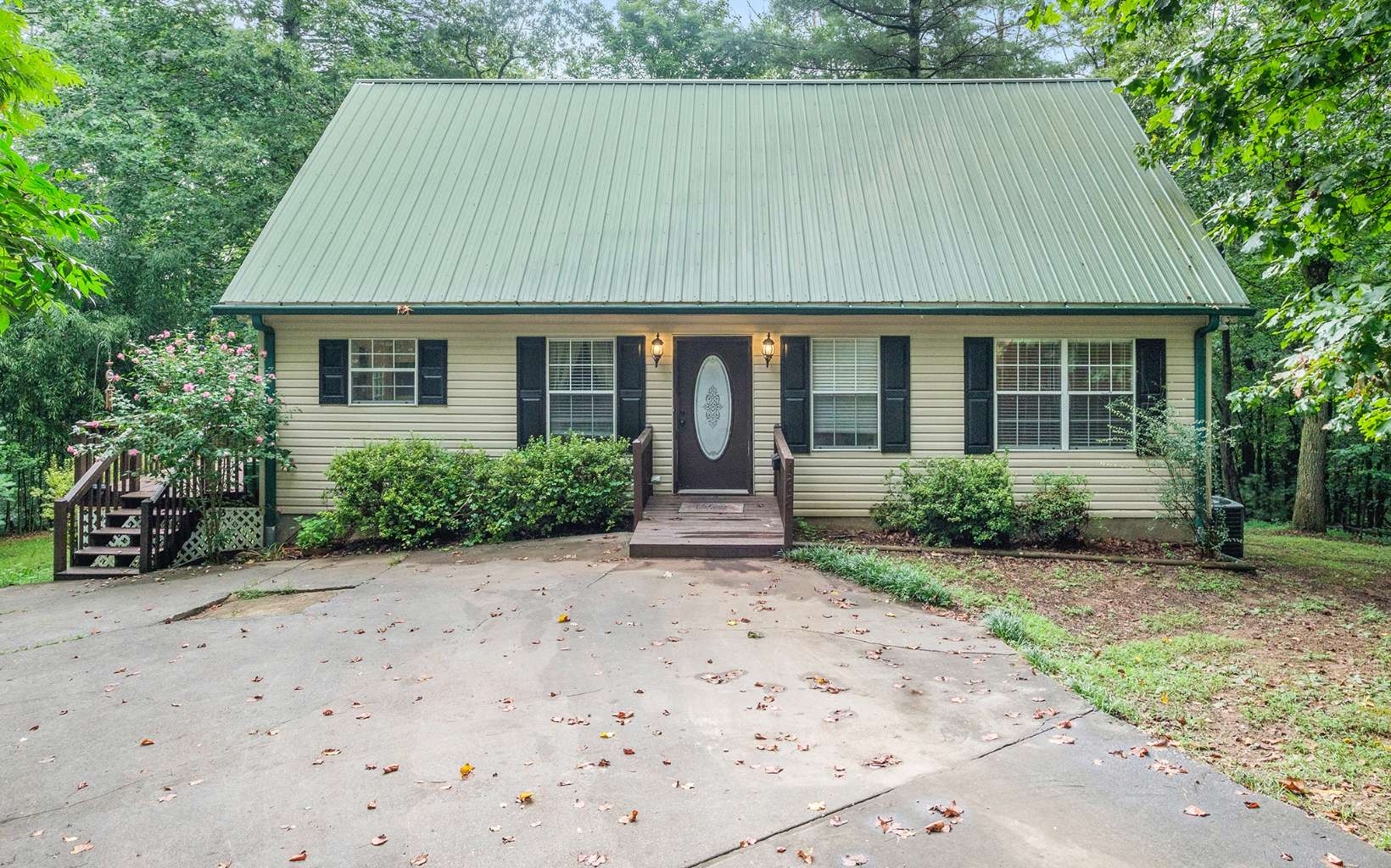 front view of house with a yard and trees