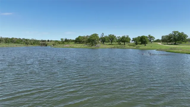 an aerial view of lake residential houses with outdoor space and trees all around