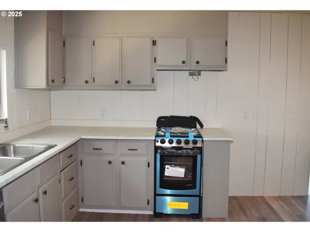 a kitchen with stainless steel appliances granite countertop a stove a sink and a white cabinets