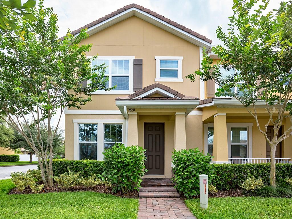 a front view of a house with a yard and trees