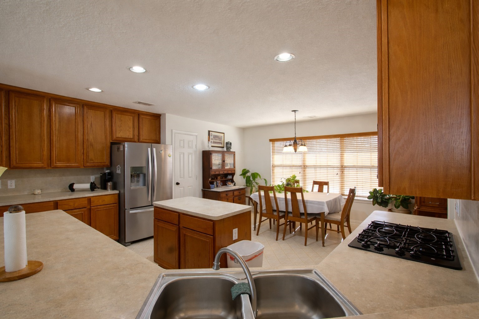 9439 Jeske Road Needville, TX 77461 - Photo 19 of 48 a kitchen with stainless steel appliances granite countertop a stove a refrigerator a sink a dining table and chairs with the floor