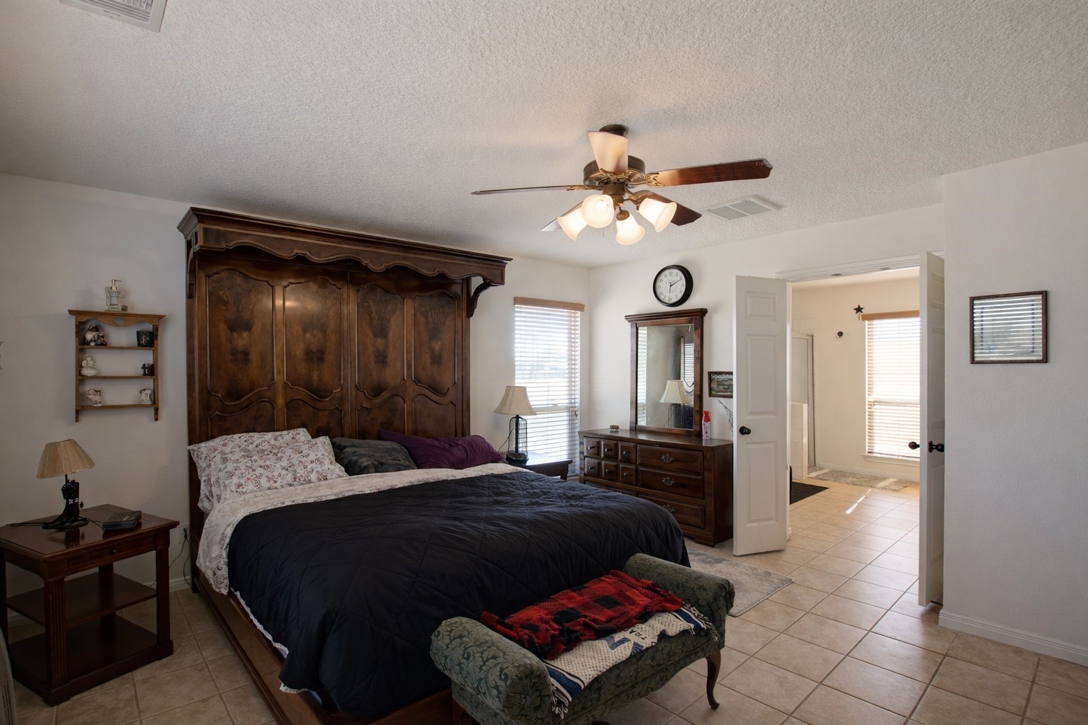 9439 Jeske Road Needville, TX 77461 - Photo 24 of 48 a bedroom with a bed a chandelier and dresser