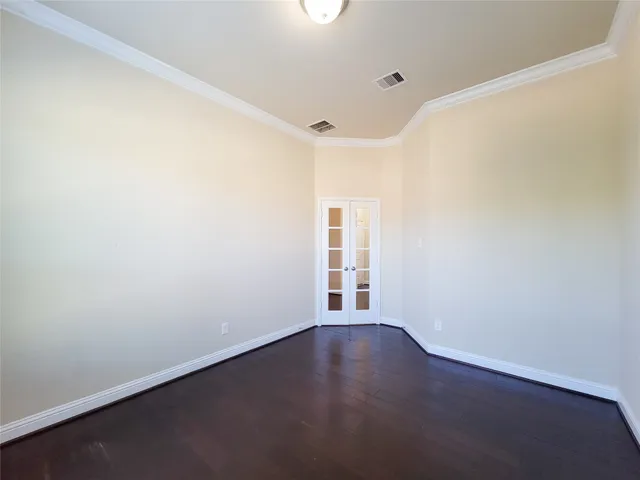 a view of an empty room with wooden floor and window