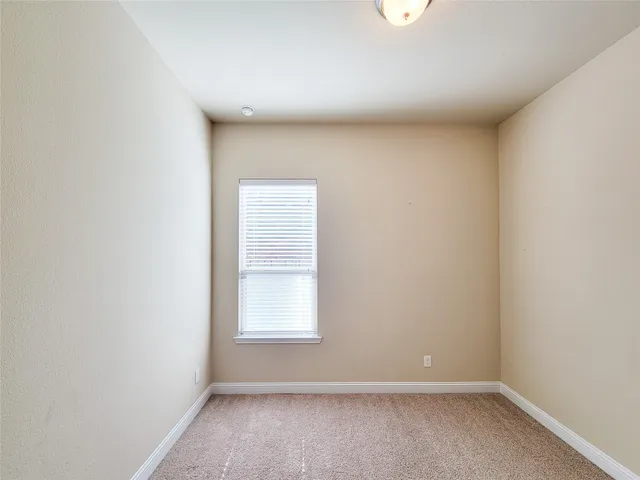 an empty room with closet and windows