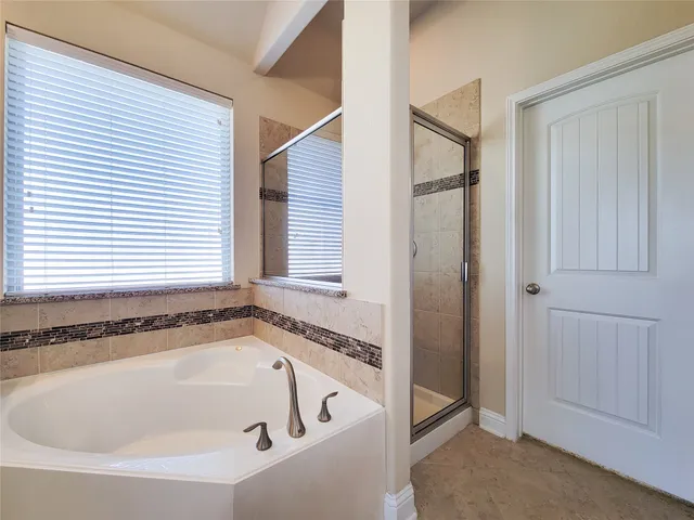 a bathroom with a granite countertop bathtub sink and mirror