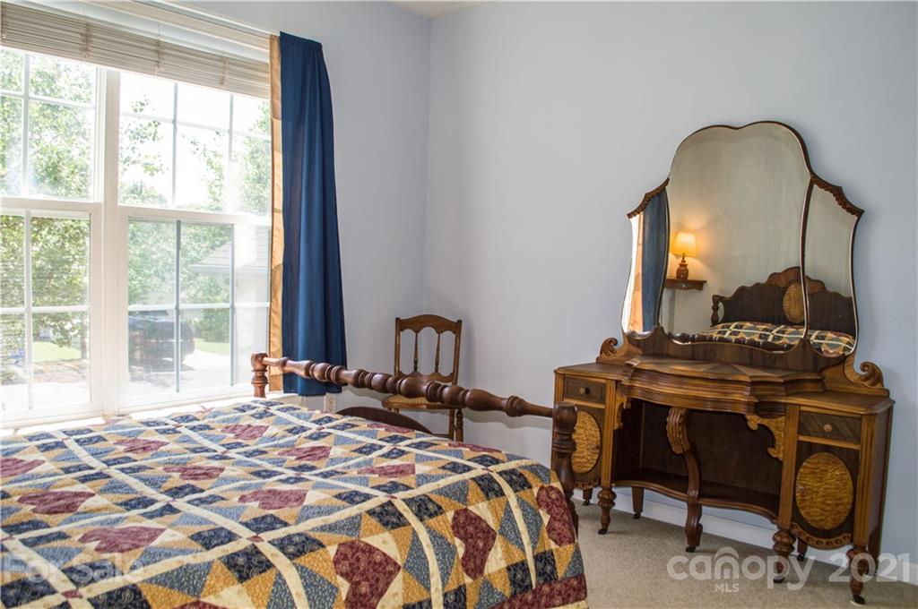 144 Amber Woods Drive Tega Cay, SC 29708 - Photo 14 of 37 a bedroom with a bed and dresser with mirror