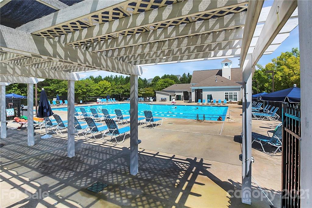 144 Amber Woods Drive Tega Cay, SC 29708 - Photo 22 of 37 a view of a patio with table and chairs potted plants
