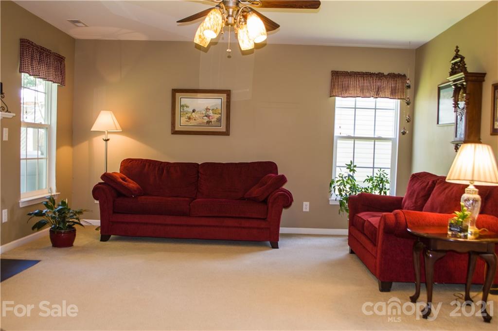 144 Amber Woods Drive Tega Cay, SC 29708 - Photo 9 of 37 a living room with furniture a chandelier and a window