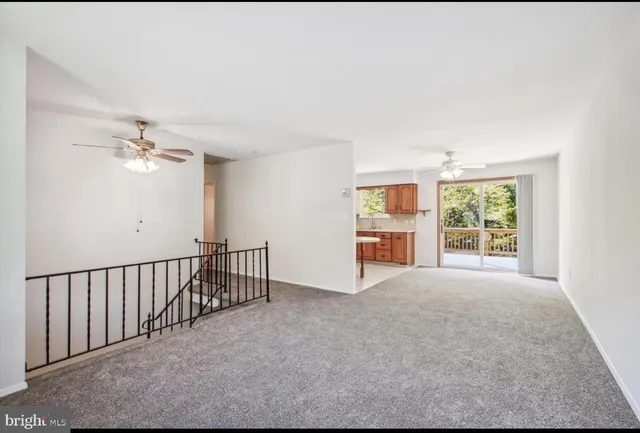 a view of a big room with windows and chandelier fan