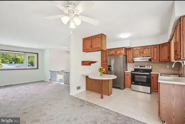 a living room with stainless steel appliances kitchen island furniture and a window