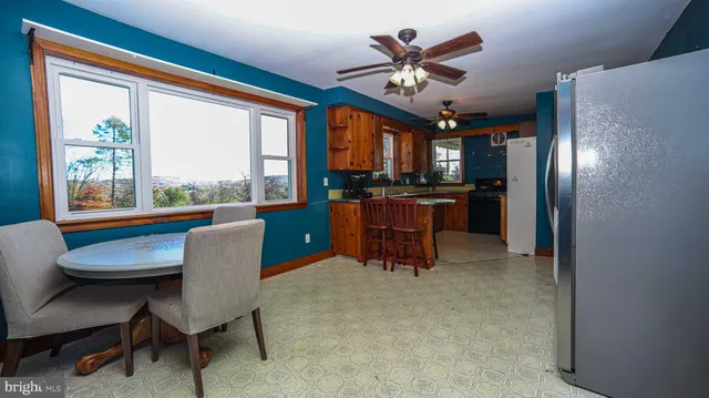 a view of a dining room with furniture a chandelier and a large window