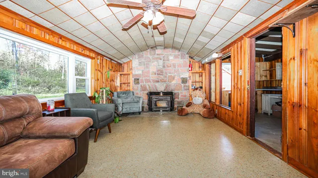 a living room with furniture a ceiling fan and a large window