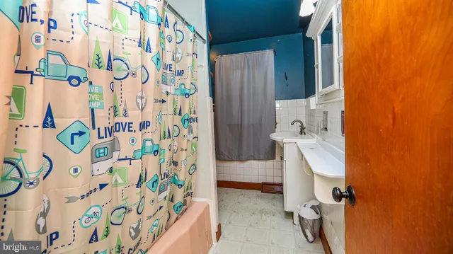 a bathroom with a sink and mirror with shower curtain
