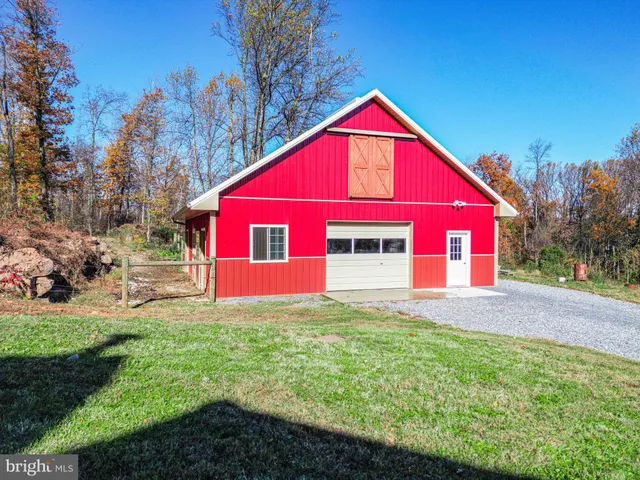 a front view of house with yard and trees in the background