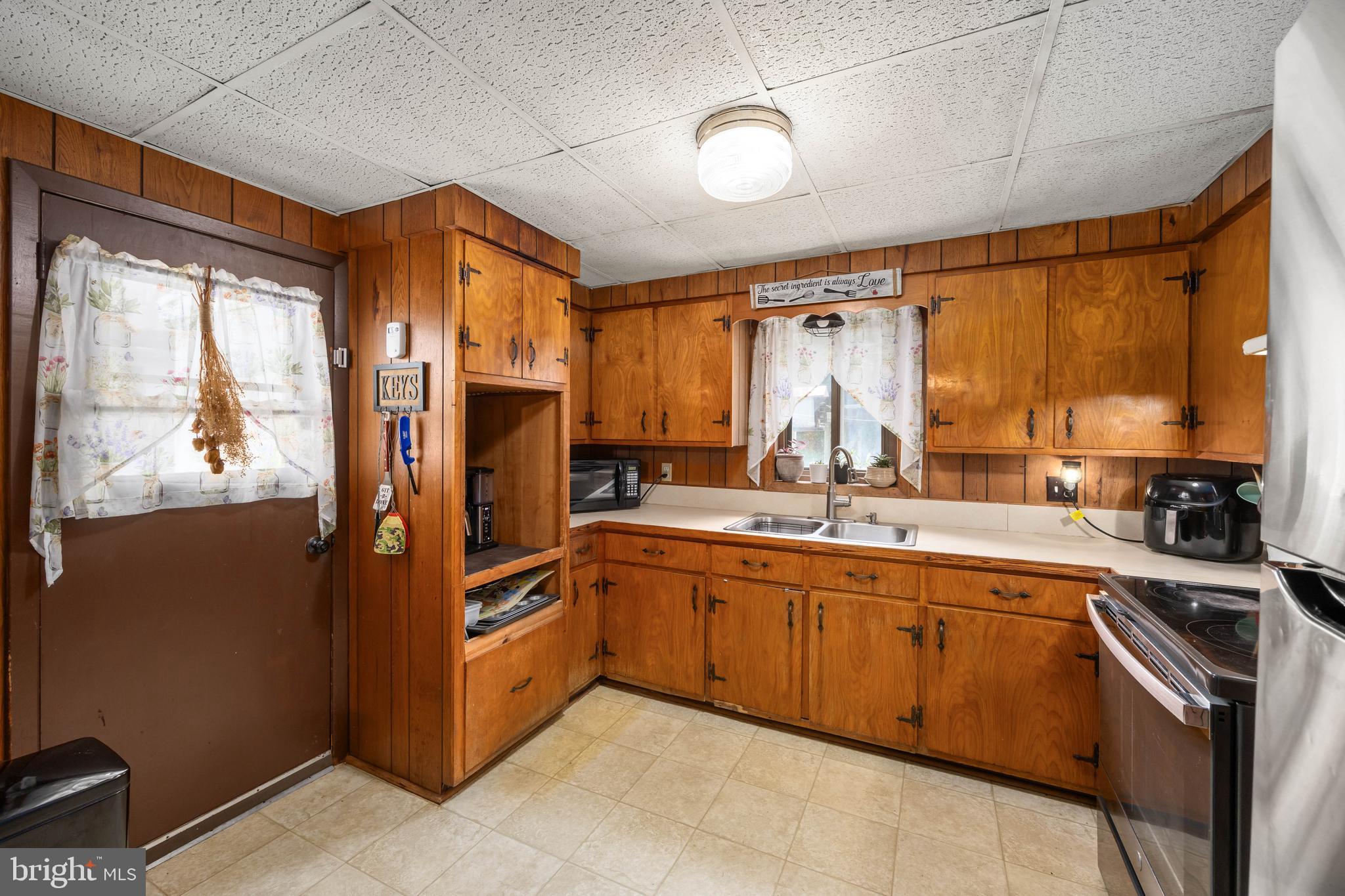 26467 Mariners Road Crisfield, MD 21817 - Photo 21 of 44 a kitchen with stainless steel appliances granite countertop a refrigerator a sink dishwasher a stove and a dining table with wooden floor
