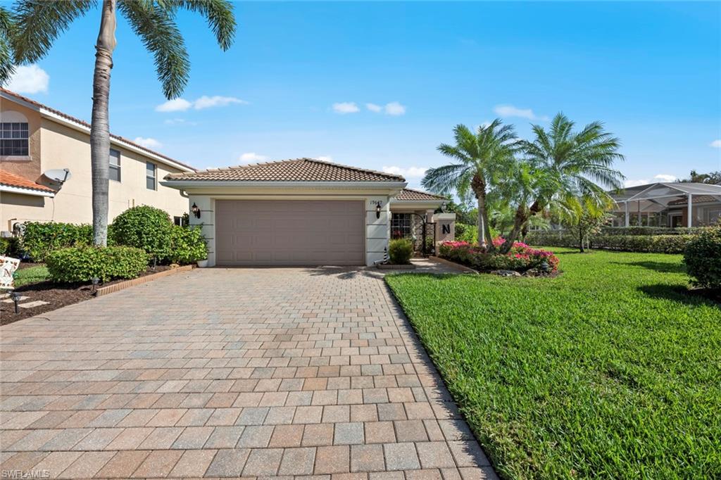 19647 Villa Rosa Loop Estero, FL 33967 - Photo 4 of 48 a front view of a house with a yard and potted plants