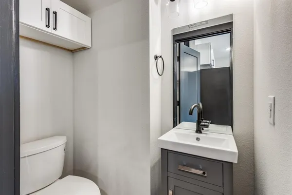 a bathroom with a toilet sink and mirror