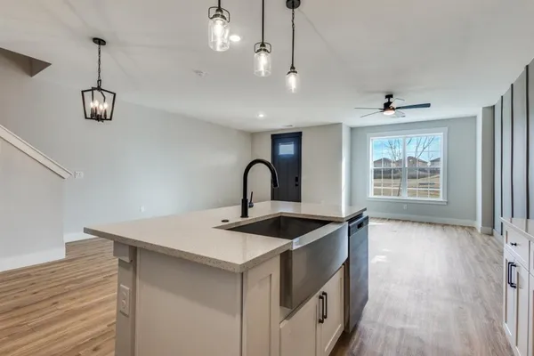 a kitchen with stainless steel appliances granite countertop a sink a stove and a wooden floor