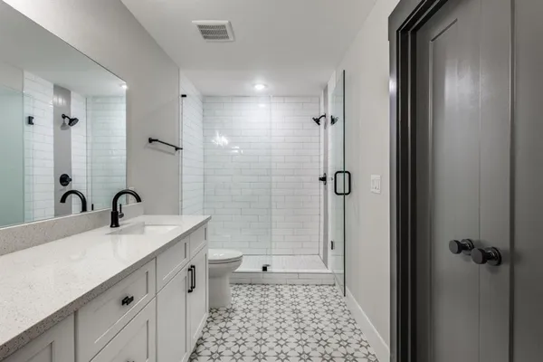 a bathroom with a double vanity sink toilet and shower