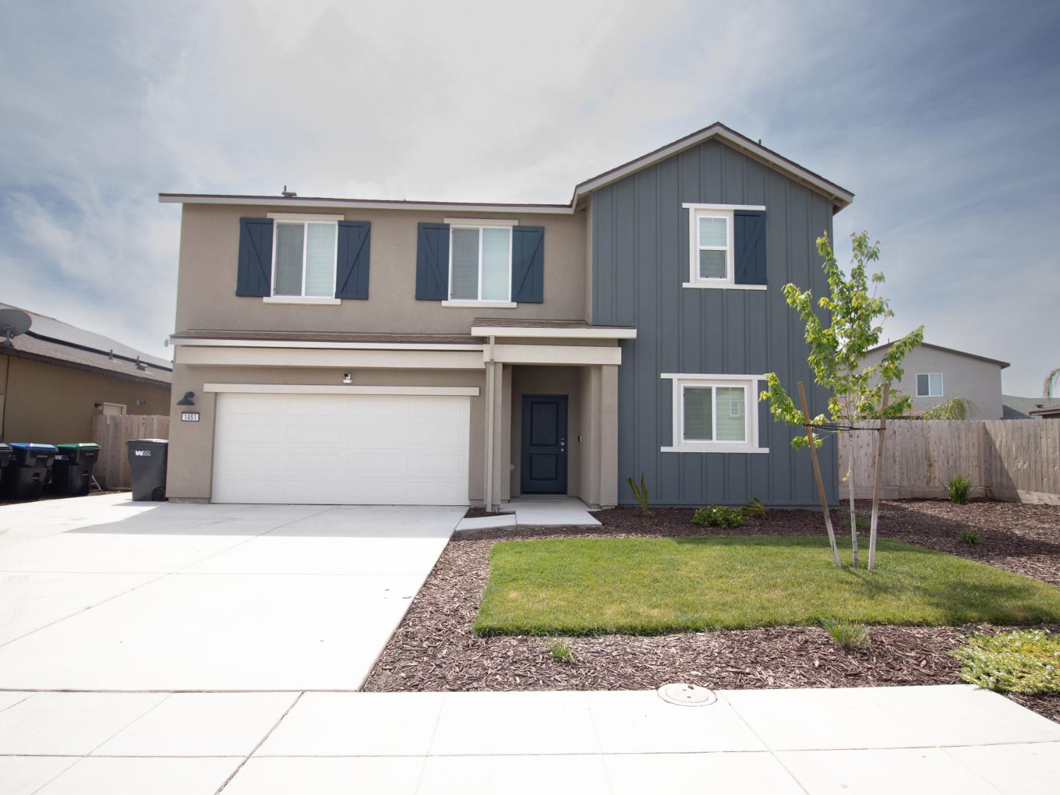 1451 Ryan Avenue Fowler, CA 93625 - Photo 1 of 23 a front view of a house with a yard and garage