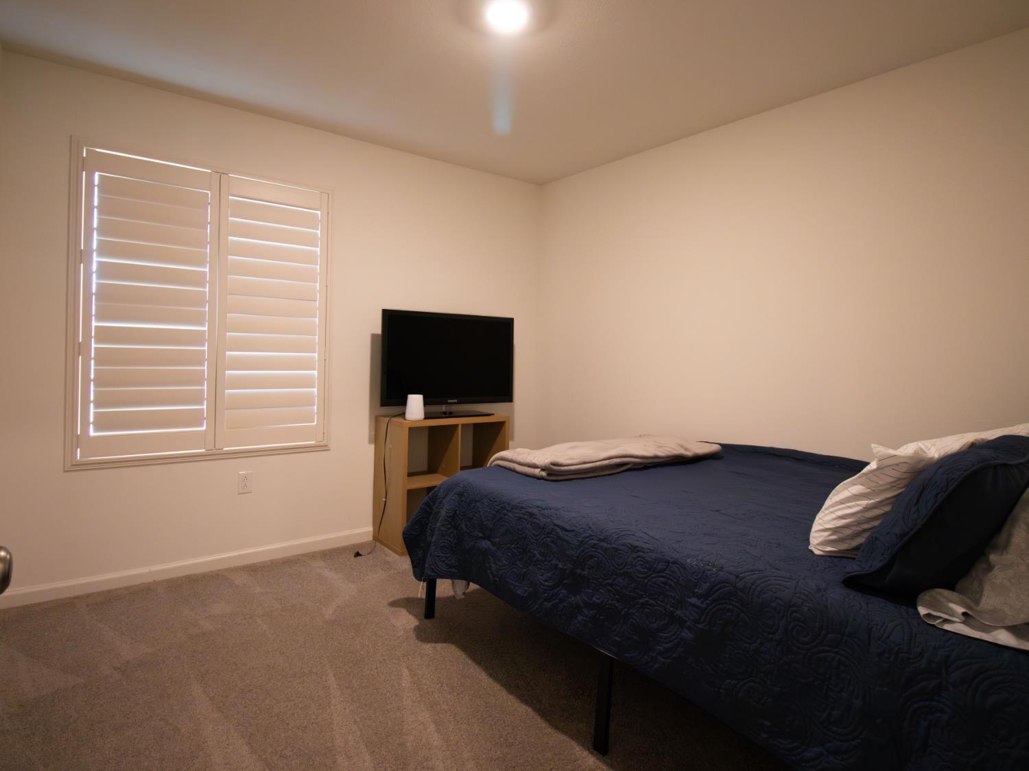 1451 Ryan Avenue Fowler, CA 93625 - Photo 18 of 23 a bedroom with a bed and a television