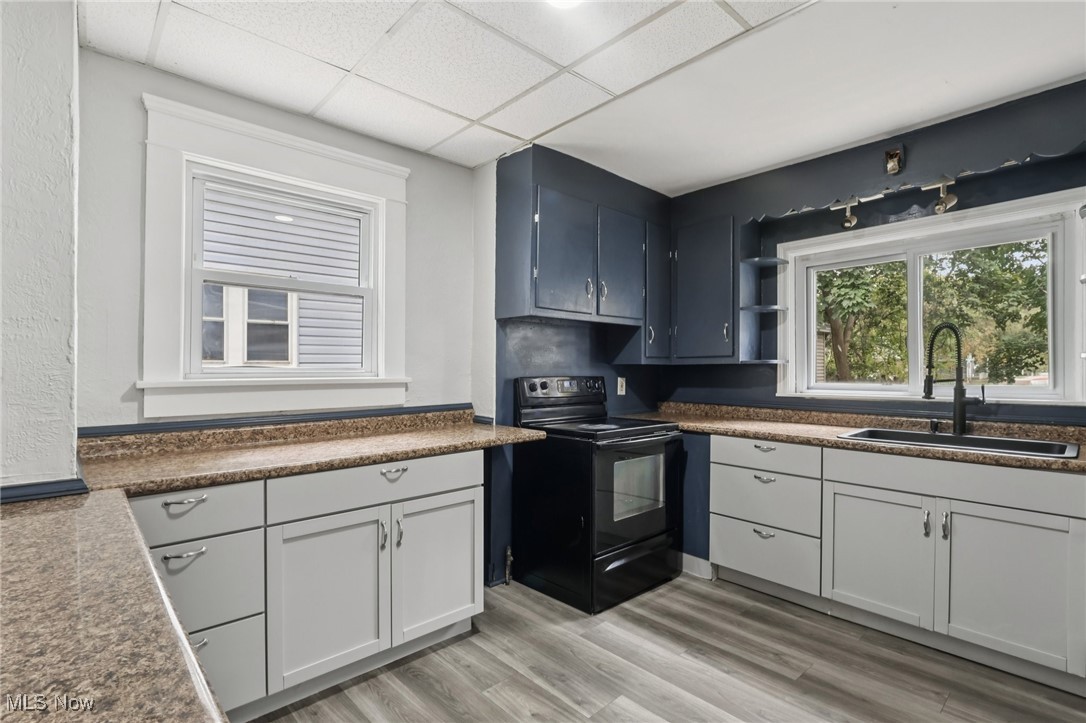 748 Chalker Street Akron, OH 44310 - Photo 11 of 48 Kitchen with black range with electric cooktop, light wood-type flooring, open shelves, and a paneled ceiling