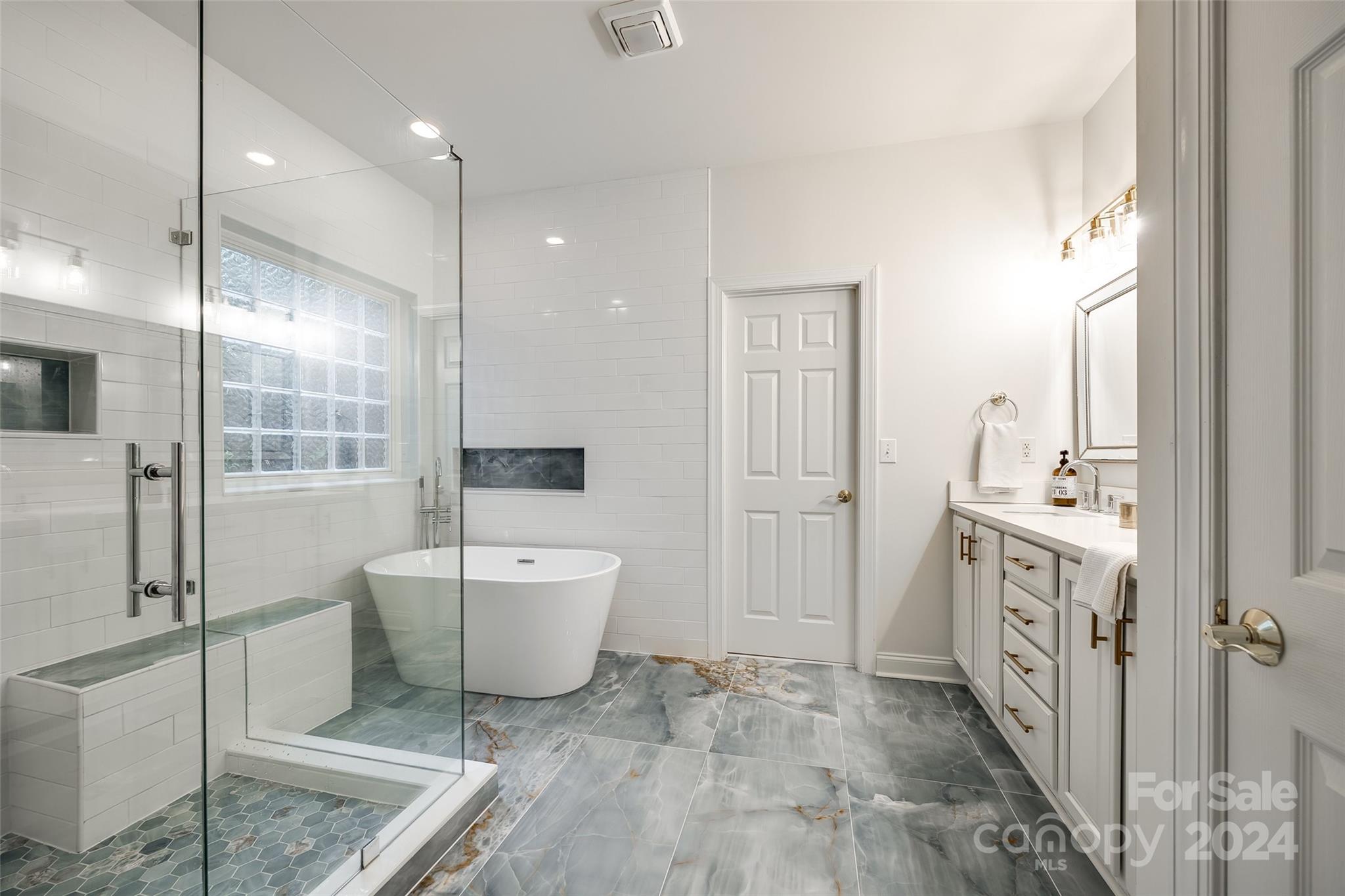 2004 Emerald Pines Drive Tega Cay, SC 29708 - Photo 18 of 30 a spacious bathroom with a double vanity sink a mirror and a bathtub