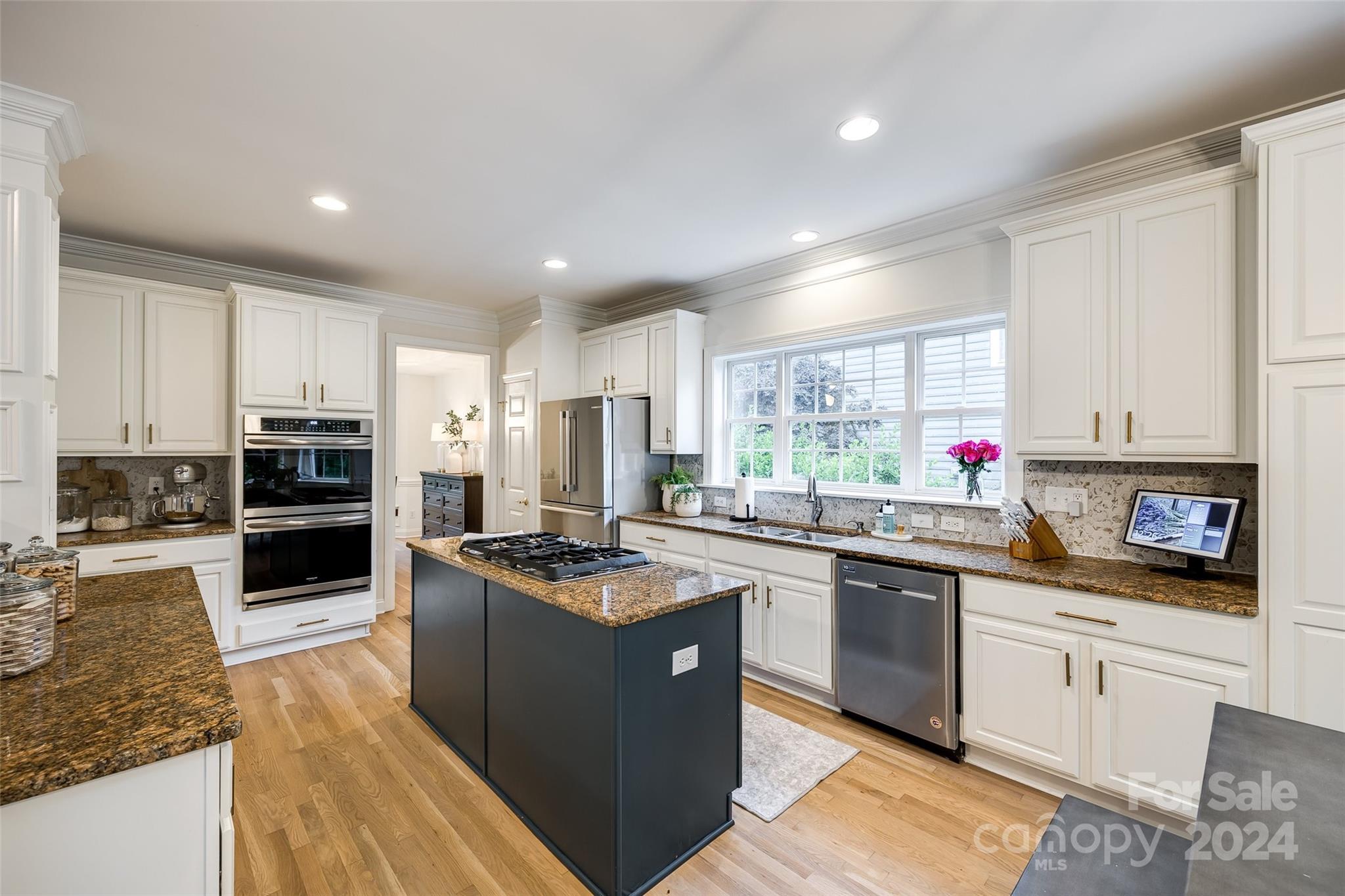2004 Emerald Pines Drive Tega Cay, SC 29708 - Photo 9 of 30 a kitchen with stainless steel appliances granite countertop a stove top oven a sink dishwasher a refrigerator and white cabinets with wooden floor