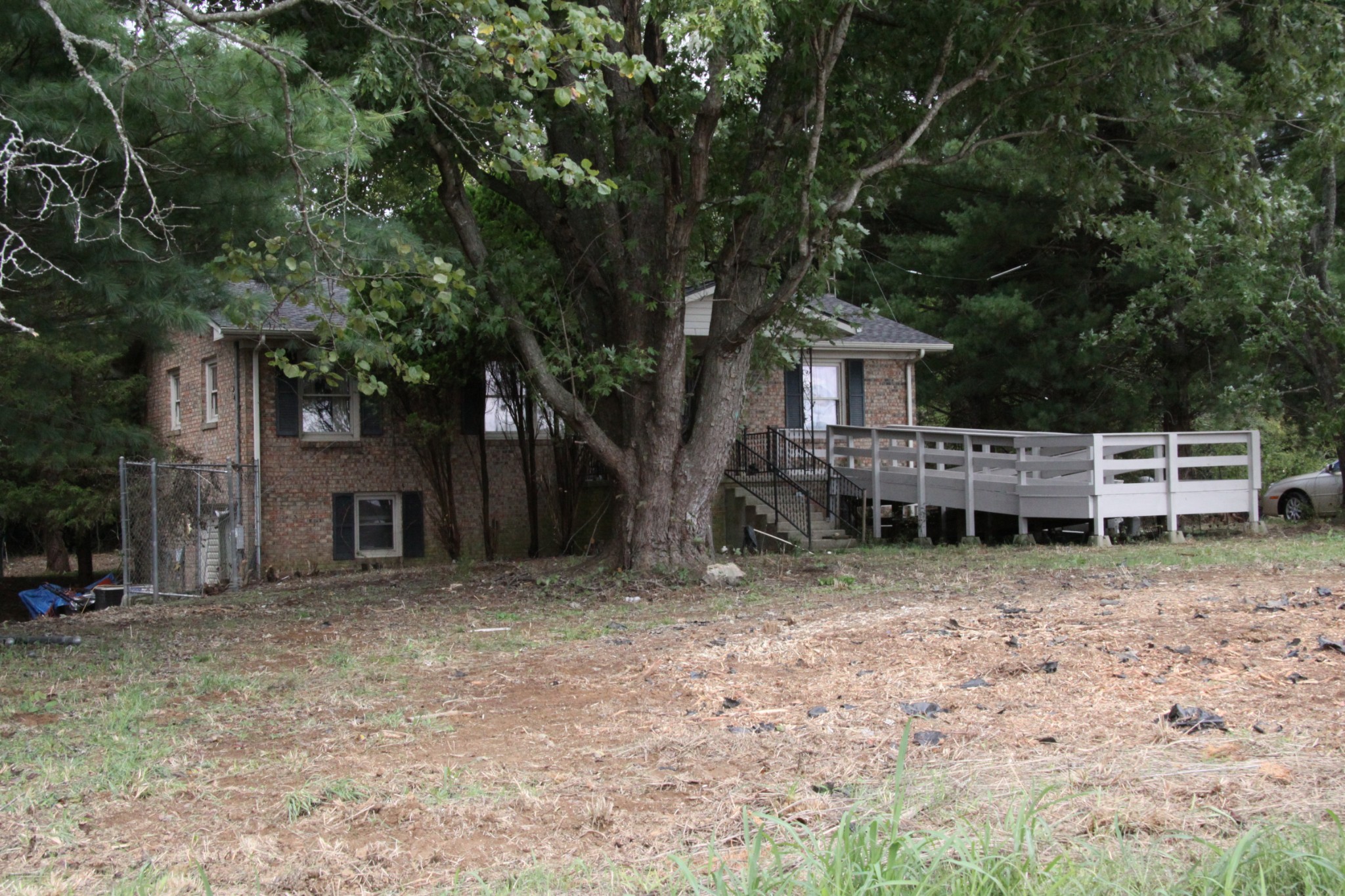 8818 Newtown Road Rockvale, TN 37153 - Photo 1 of 17 a wooden house with large trees and wooden fence