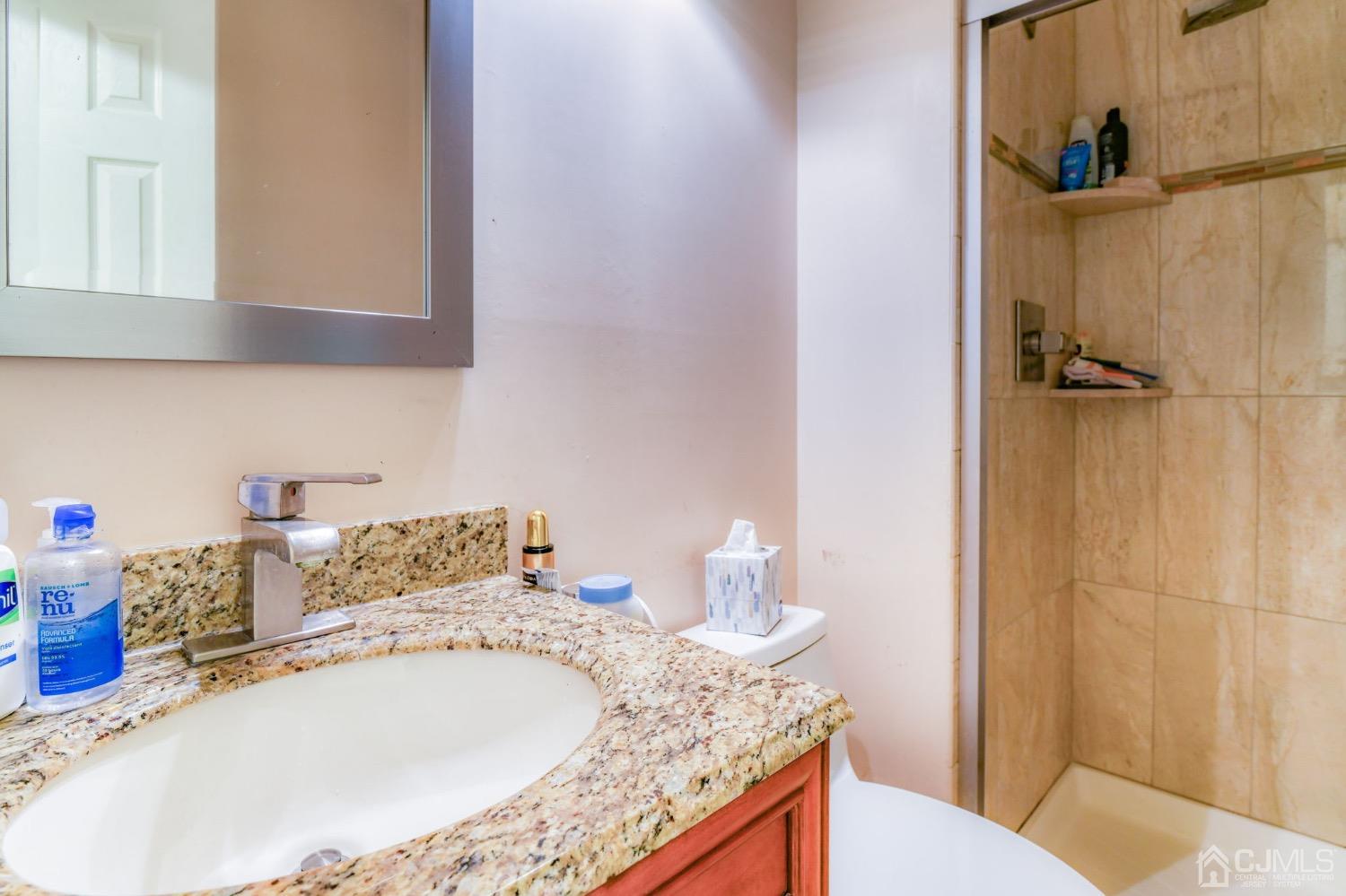 542 Westgate Drive Edison, NJ 08820 - Photo 13 of 30 a bathroom with a granite countertop sink and a mirror