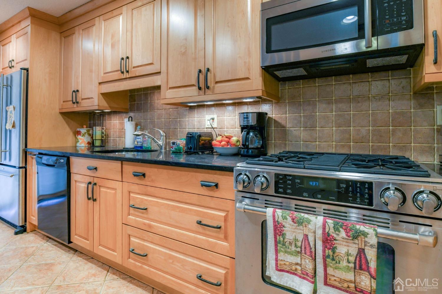 542 Westgate Drive Edison, NJ 08820 - Photo 14 of 30 a kitchen with stainless steel appliances granite countertop a stove and cabinets