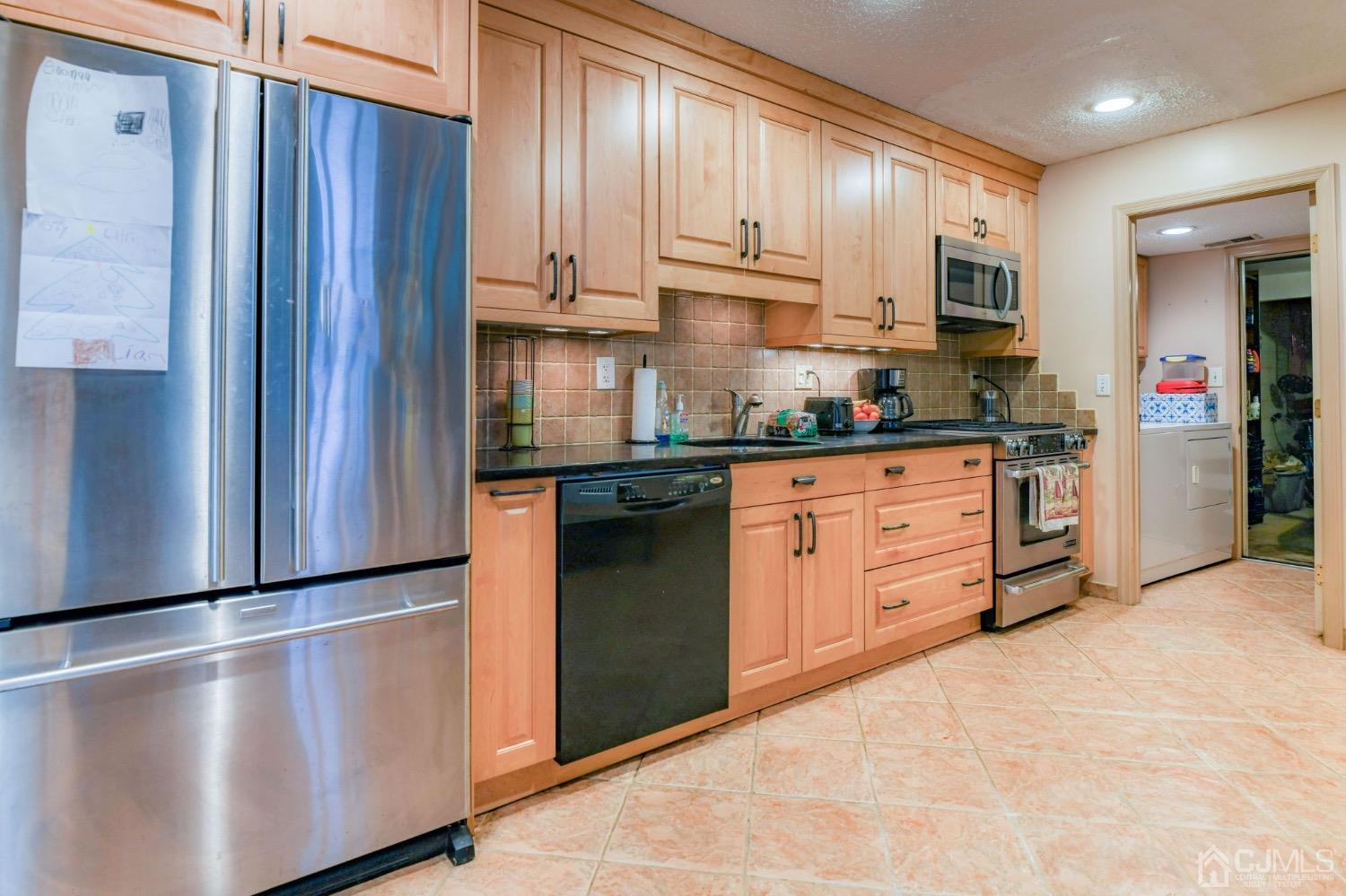542 Westgate Drive Edison, NJ 08820 - Photo 7 of 30 a kitchen with stainless steel appliances granite countertop a refrigerator and a stove top oven
