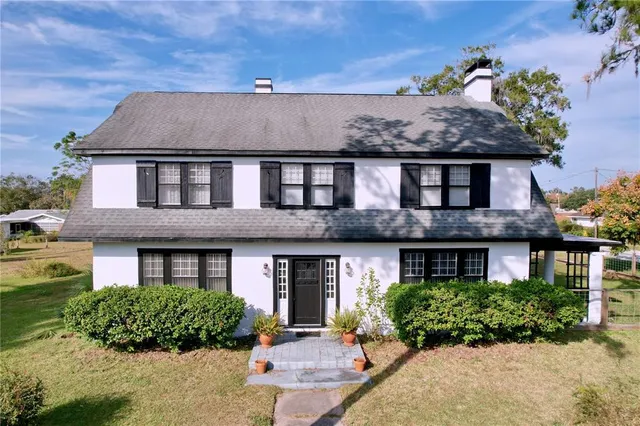 a front view of a house with garden and plants