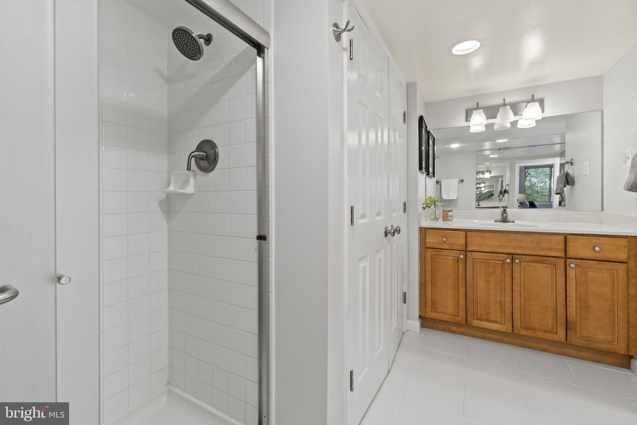 1515 South Arlington Ridge Road, Unit 603 Arlington, VA 22202 - Photo 11 of 22 a spacious bathroom with a granite countertop sink a mirror and shower