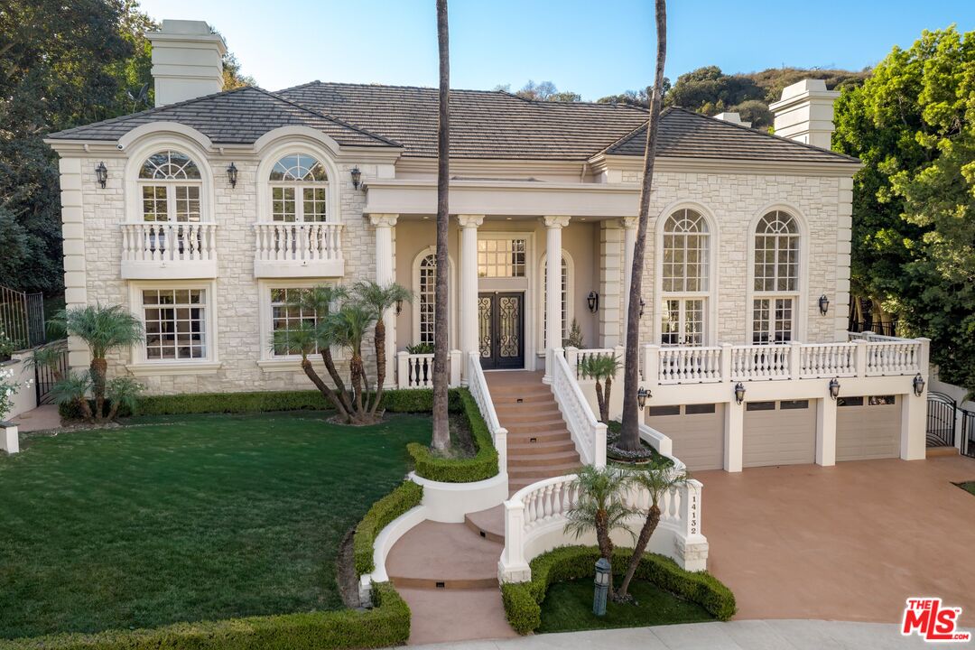 a view of a white house with a yard and potted plants